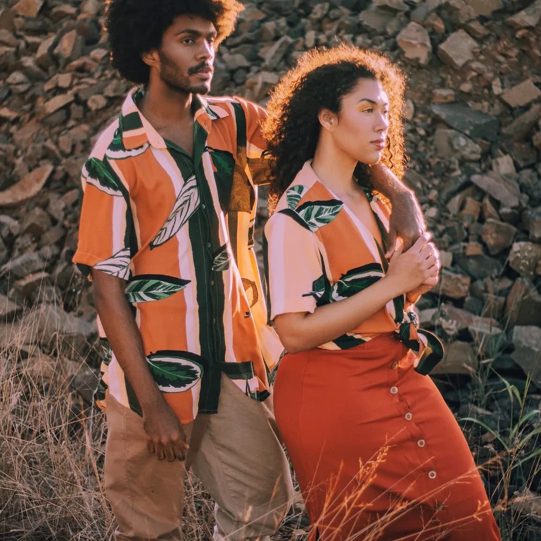 Casal no fim de tarde, os dois com a camisa folhas laranja e verde